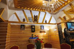 Pensiunea Meteora في سوسيفا: غرفة طعام بجدران خشبية وثريا
