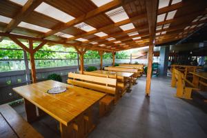rzędu drewnianych stołów i ławek w restauracji w obiekcie Pensiunea Meteora w Suczawie