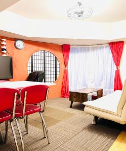 ein Wohnzimmer mit roten Stühlen und einem Tisch in der Unterkunft Susukino Tower Apartment アムスタワー in Sapporo