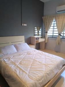 a bedroom with a large white bed with a window at AL Cozy Seri Kuantan Home in Kuantan