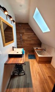 a bathroom with a sink and a bath tub at Maison La Bonbonnière chaleureuse avec parking et garage gratuit proche frontière in Forstfeld