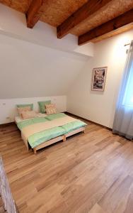 a bedroom with a bed and a wooden floor at Maison La Bonbonnière chaleureuse avec parking et garage gratuit proche frontière in Forstfeld