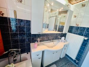 a bathroom with a sink and a mirror and a tub at Haus Gruber - Valentina & Gabriel in der Waldheimat in Krieglach