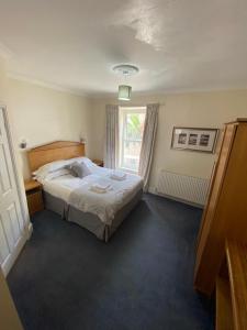 a bedroom with a large bed with a window at Rose and Crown in Goodwick