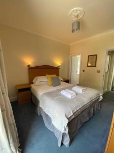 a bedroom with a large bed with two towels on it at Rose and Crown in Goodwick