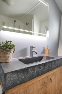 W łazience znajduje się umywalka i lustro. w obiekcie Beautiful 6-person chalet with Finnish wood-fired sauna w mieście Tzummarum