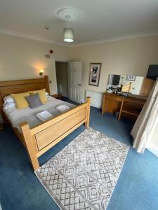 um quarto com uma cama grande e um tapete em Rose and Crown em Goodwick