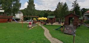 un parque infantil con niños jugando en un parque en Plně vybavený 2+1byt s balkonem a kójí pro kola a lyže., en Rokytnice v Orlických horách