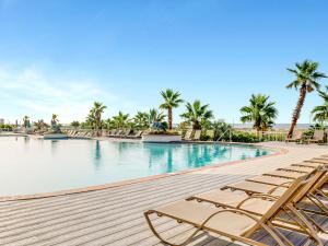 een zwembad met ligstoelen en palmbomen bij Caribe The Resort #C504 in Orange Beach