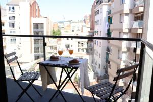 a balcony with a table and two glasses of wine at Weflating Modern Diagonal in Barcelona