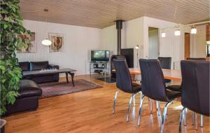 ein Wohnzimmer mit einem Tisch, Stühlen und einem Sofa in der Unterkunft Pet Friendly Home In Blvand With Sauna in Blåvand