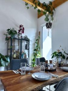 einem langen Holztisch mit Tellern und Gläsern darauf in der Unterkunft SKYLINE Penthouse Apartment - Luxus & Zentral in Braunschweig