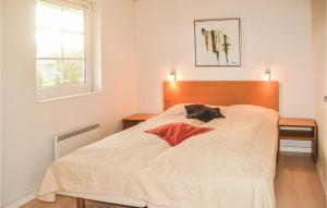 Lønne HedeにあるNice Home In Nrre Nebel With 3 Bedrooms, Wifi And Indoor Swimming Poolの白いベッド1台(木製ヘッドボード付)が備わるベッドルーム1室が備わります。