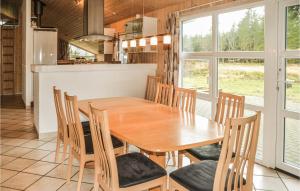 MosevråにあるAmazing Home In Oksbl With 5 Bedrooms, Sauna And Indoor Swimming Poolのキッチン、ダイニングルーム(木製のテーブルと椅子付)