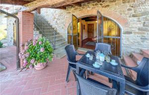 een patio met een tafel en stoelen en een trap bij Cozy Home In Bibbiena With Kitchen in Bibbiena