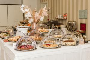 un buffet de postres y repostería en una mesa en Palazzo Bezzi Hotel en Rávena