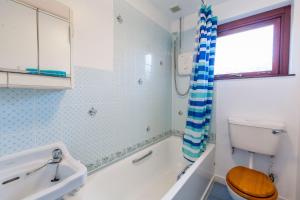Un baño con bañera, inodoro y lavabo. en Laghead Cottage, en Gatehouse of Fleet