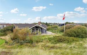 a house in the middle of a field with a flag at Beautiful Home In Rm With 3 Bedrooms, Sauna And Wifi in Bolilmark