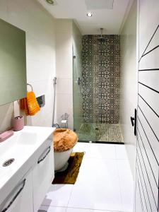 een badkamer met een douche, een toilet en een wastafel bij appartement plage mahdia sable dor in Kenitra