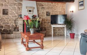 - un salon avec une table et des fleurs dans l'établissement Amazing Home In Pluvigner With Wifi, à Pluvigner