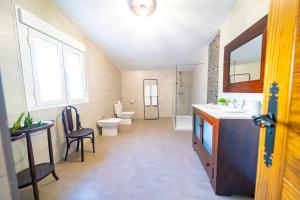 a bathroom with a sink and a toilet and a mirror at Casa Rural Casa Las Flores in Tíjola +26 photos