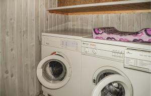 a laundry room with a washing machine and a washer at Awesome Home In Oksbl With 3 Bedrooms And Wifi in Ovtrup