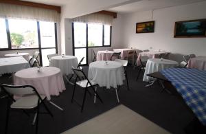 a room with tables and chairs with white table cloth at Goren Hotel in Çeşme