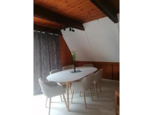 a dining room with a white table and chairs at Twistesee Ferienhaus 2 in Bad Arolsen