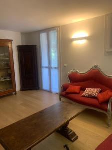 een woonkamer met een rode bank en een houten tafel bij Le Stanze del Brigante in Genua