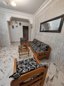 Habitación con 2 camas y espejo en la pared. en Appartement S+2 vue mer 20 mètres pieds dans l'eau, en Port El Kantaoui