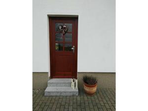 a wooden door on a building with a potted plant at Krohn in Großpösna