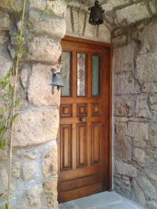 a wooden door in a stone building with a lamp at Apartment Seminello in Pitigliano