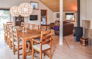 OksbølにあるNice Home In Oksbl With Kitchenのダイニングルーム、リビングルーム(木製テーブル、椅子付)