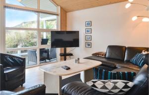 een woonkamer met een bank, een tv en een tafel bij Lovely Home In Henne With House A Panoramic View in Henne Strand