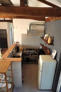 a small kitchen with a refrigerator and a sink at 古民家ここにわ はなれの宿 in Furano