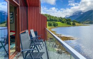 a balcony with chairs overlooking a lake and mountains at Nice Apartment In Straumgjerde With Wifi And 2 Bedrooms 