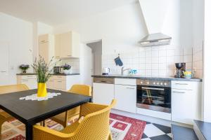 a kitchen with a table and yellow chairs in a room at Apartment "Deluxe" Innsbruck - Mutters in Innsbruck