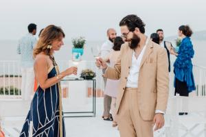 a woman talking to a man at a wedding ceremony at Boutique Hotel I Cinque Balconi in Santa Marina Salina