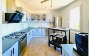 eine Küche mit weißen Schränken und blauen Arbeitsplatten in der Unterkunft Gorgeous Home In Ussel With Wifi in Ussel