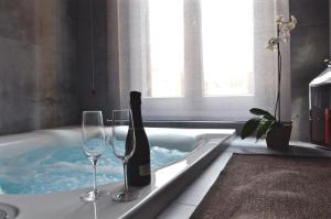una vasca da bagno con 2 bicchieri e una bottiglia di vino di Place 24 Suites & Wellness a Roma Altre 34 foto