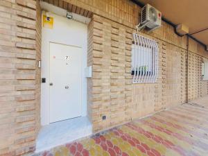 a brick wall with a white door and a window at Vivienda Turistica Valencia 2 in Valencia