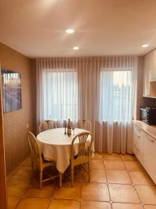 comedor con mesa y sillas y cocina en Exclusive Jacuzzi Villa Kretinga en Kretinga