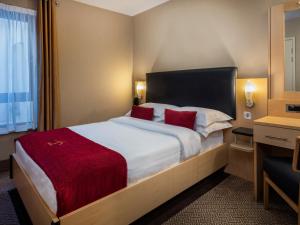 una habitación de hotel con una cama grande con almohadas rojas en Academy Plaza Hotel, en Dublín