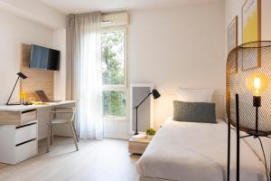 a bedroom with a bed and a desk and a computer at Apparteo Montpellier in Montpellier