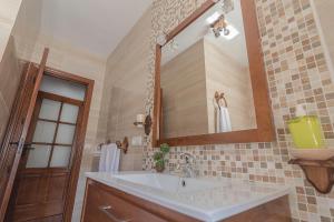 La salle de bains est pourvue d'un lavabo et d'un miroir. dans l'établissement Apartamentos Rurales Las Chimeneas, à Capileira