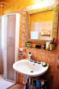 baño con lavabo, espejo y nevera en Casa Fiorenza, en Montefelcino