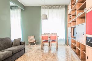 ein Wohnzimmer mit einem Sofa und einem Tisch mit Stühlen in der Unterkunft Margreth Apartment in Mailand