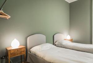 ミラノにあるMargreth Apartmentのランプ2つが付いた部屋のベッド2台
