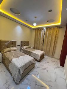 two beds in a room with a marble floor at Selouane in Nador