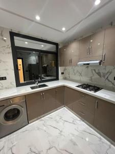 uma cozinha com bancadas em mármore e um lavatório em Selouane em Nador